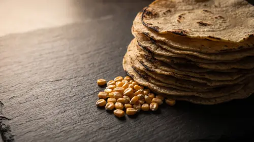 A stack of corn tortillas with dried corn.
